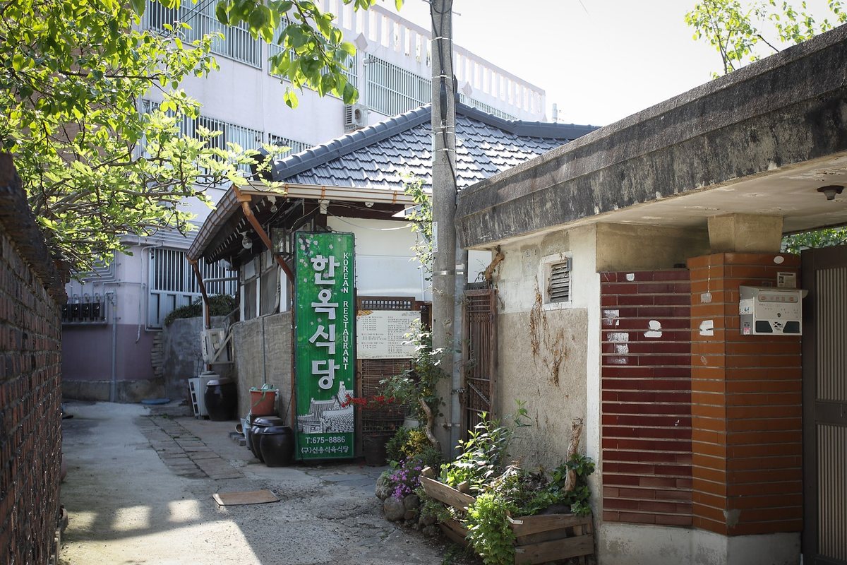 초록 세로 간판이 선 한옥식당 기와집 외관