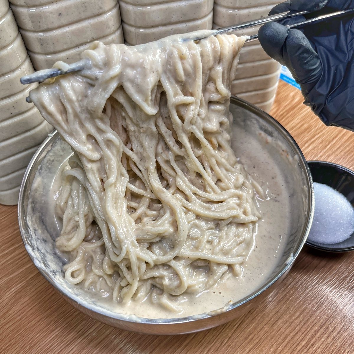 젓가락으로 들어 올린 맷돌 콩물국수 면발