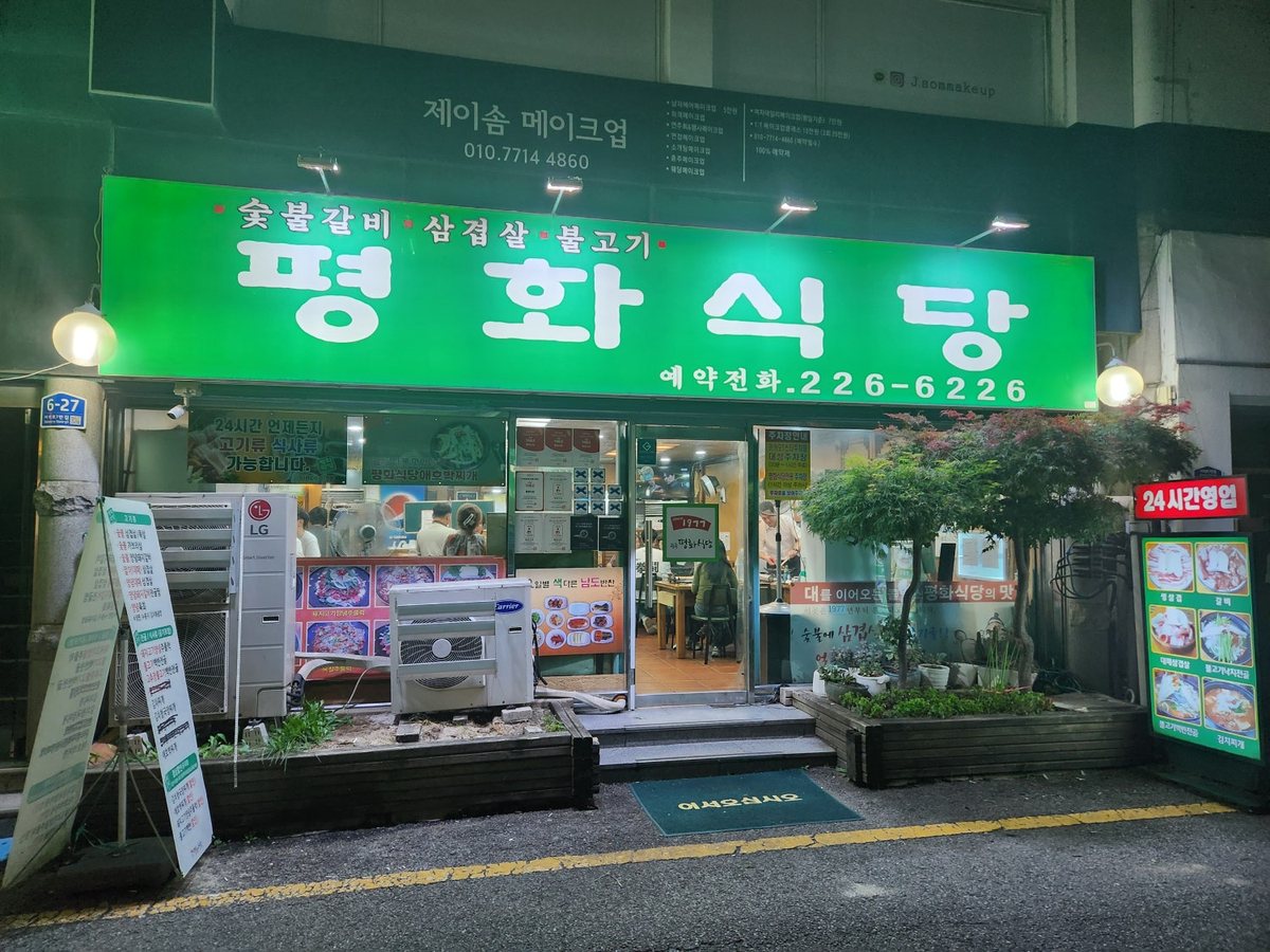초록 간판이 켜진 평화식당 가게 앞(밤)