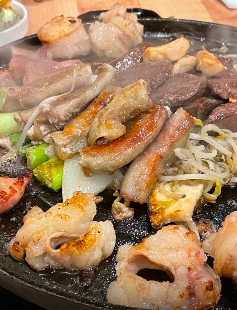 돌판 위에서 노릇하게 구워지는 곱창·대창과 양파·숙주