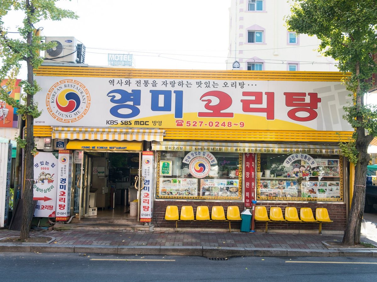 노란 간판과 노란 대기 의자가 있는 영미오리탕 가게 앞