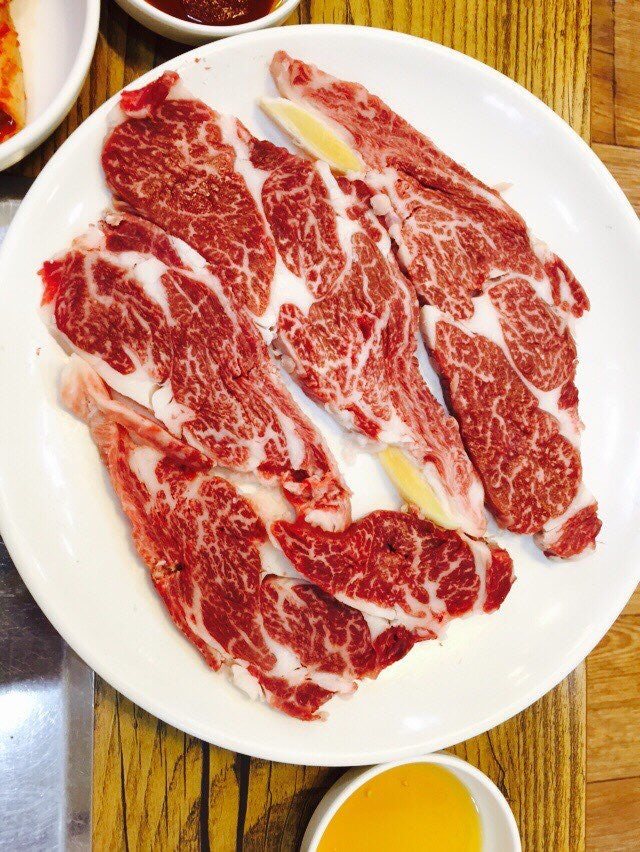 마블링이 보이는 한우 구이용 고기 한 접시