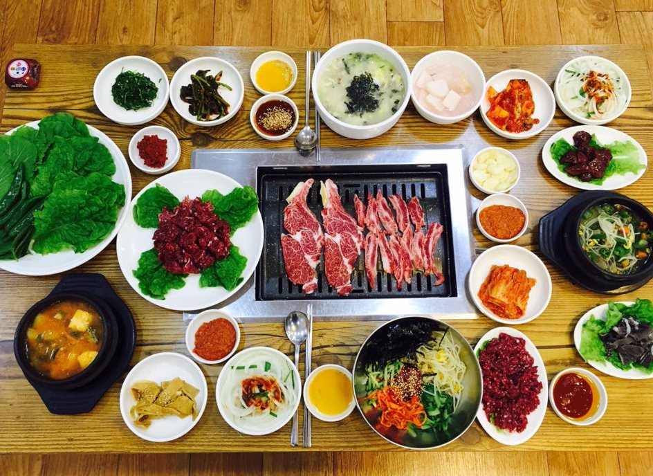 석쇠 불판을 가운데 두고 생고기·육회·비빔밥·찌개와 여러 반찬을 차린 한 상